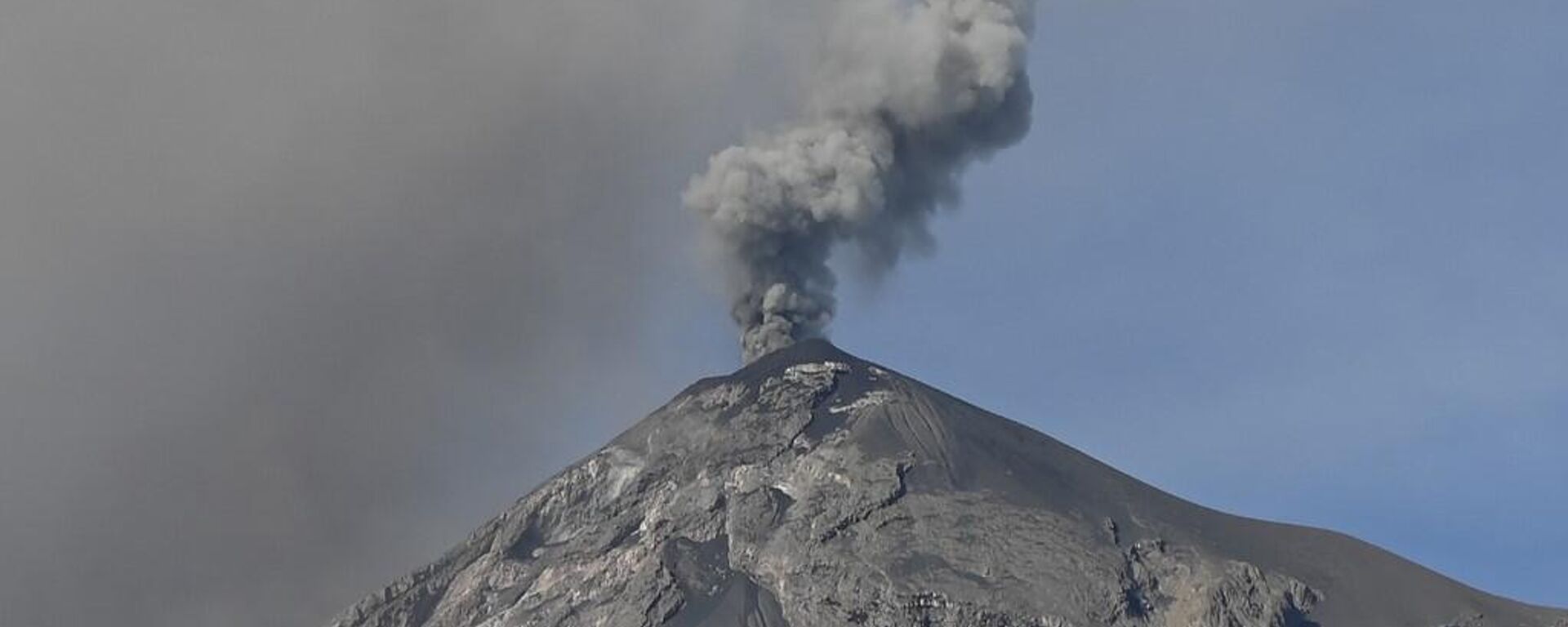Una columna de ceniza y humo se eleva desde el Volcán de Fuego, visto desde Alotenango, un municipio en el departamento de Sacatepéquez, a 65 kilómetros al suroeste de Ciudad de Guatemala el 11 de diciembre de 2022.  - Sputnik Mundo, 1920, 05.05.2023