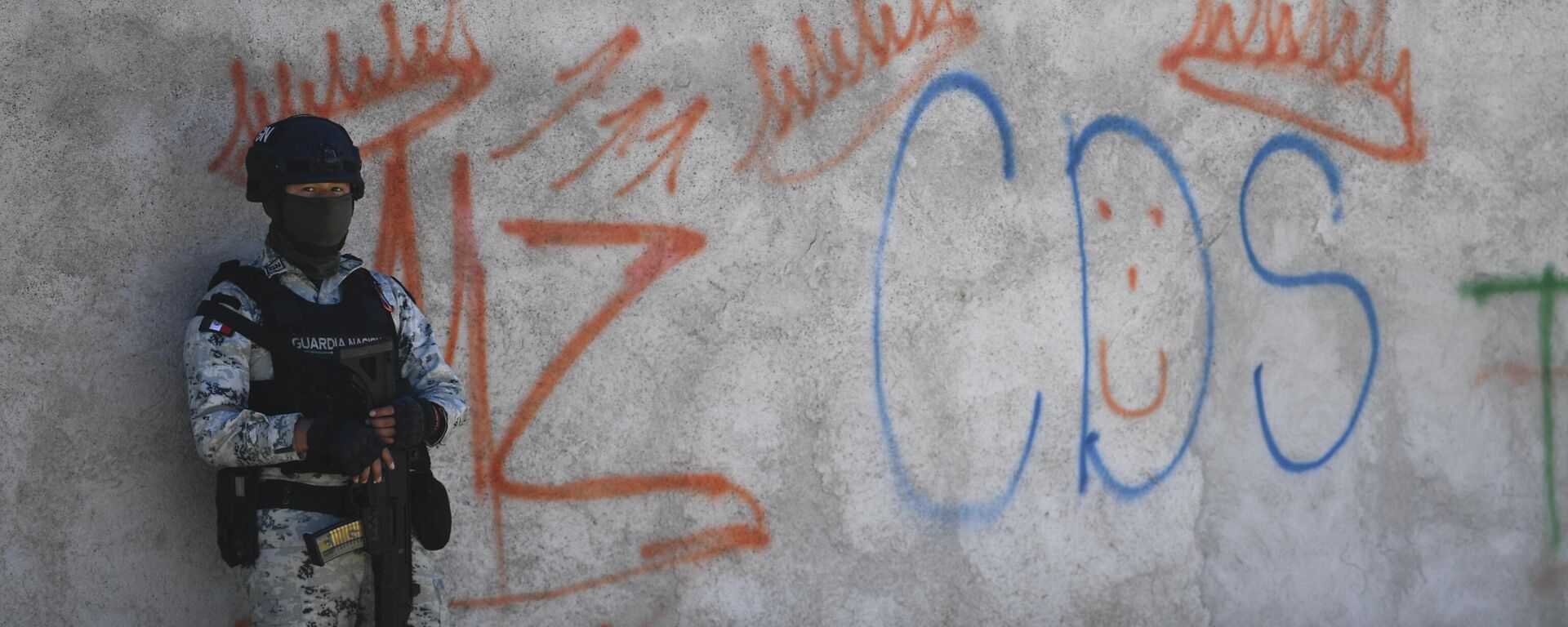 Un soldado mexicano monta guardia junto a unos grafitis alusivos al grupo criminal cártel de Sinaloa en el poblado Palmas Altas, en el estado de Zacatecas, México.  - Sputnik Mundo, 1920, 06.05.2023