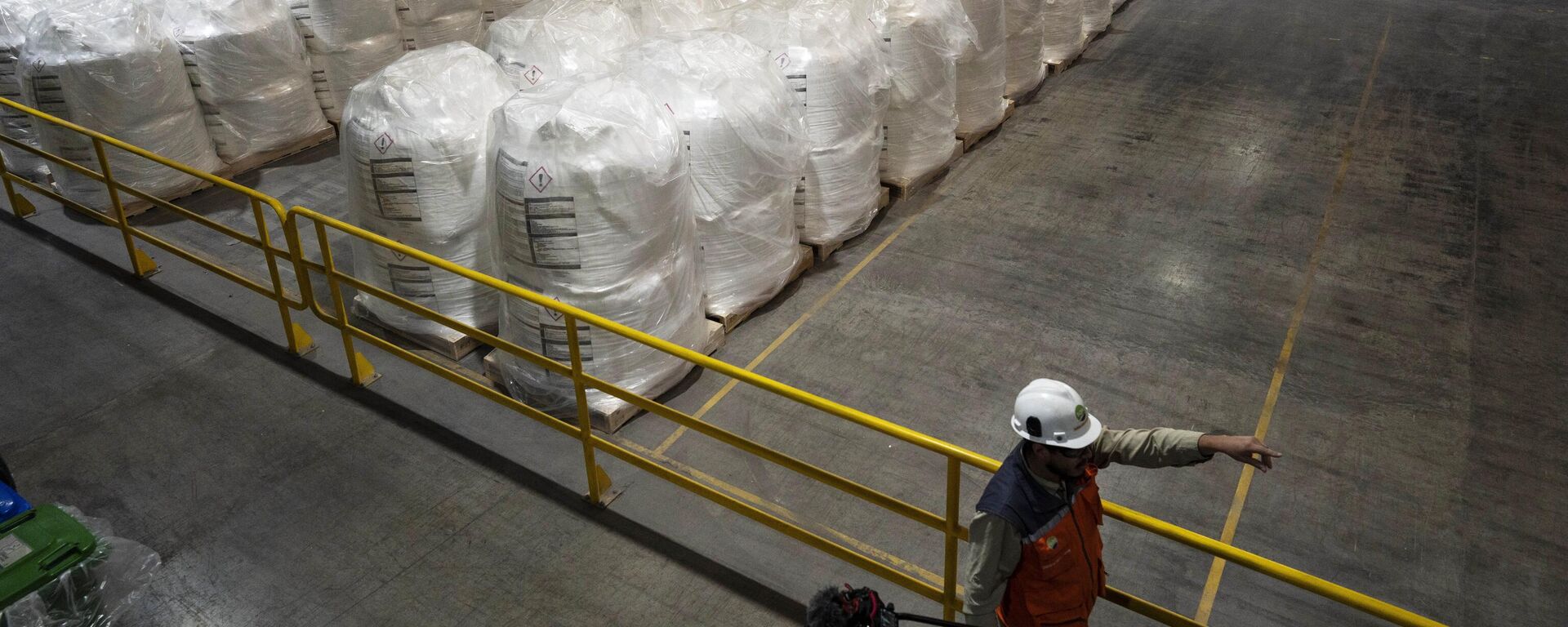 Un trabajador camina junto a sacos de litio listos para exportar en la planta procesadora de SQM en Antofagasta, Chile, el 19 de abril de 2023. - Sputnik Mundo, 1920, 18.10.2023