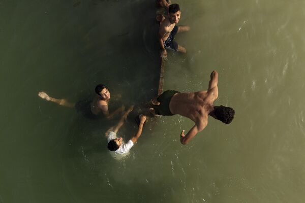 Unos jóvenes se bañan en el río Chat el Arab, formado en la confluencia de los ríos Tigris y Éufrates, en la ciudad meridional iraquí de Basora. - Sputnik Mundo
