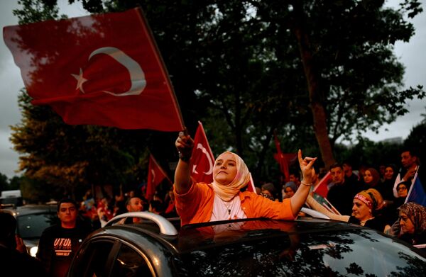 Según la Comisión Electoral Central, el 52,14% de los electores votaron a Erdogan y el 47,86% a su oponente Kemal Kilicdaroglu. La participación superó el 85%. En la foto: una partidaria de Erdogan frente a la oficina del partido gobernante AK en la mayor ciudad del país, Estambul. - Sputnik Mundo