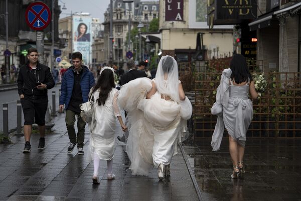 Una novia y sus damas de honor en una calle del centro de Bucarest, Rumanía. - Sputnik Mundo