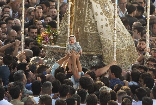 Peregrinos colocan un bebé sobre una imagen de la Virgen del Rocío en la aldea de El Rocío, Andalucía, España. - Sputnik Mundo