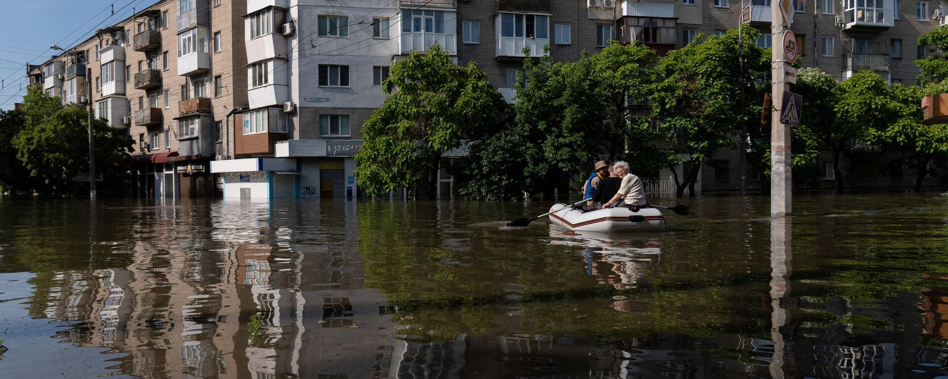 Residentes locales en un bote durante una evacuación de un área inundada en Jersón el 7 de junio de 2023 - Sputnik Mundo, 1920, 11.06.2023
