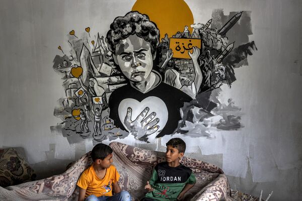 Un grupo de niños israelíes ante un mural en la pared de una de las casas destruidas de Deir al-Balah. - Sputnik Mundo