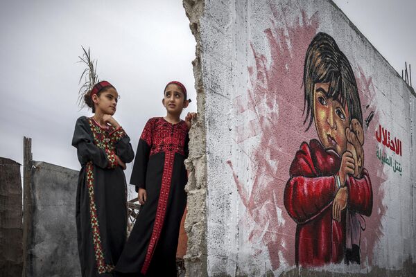 Israel, por su parte, se niega a volver a las fronteras de 1967 y a dividir Jerusalén.En la foto: Niños palestinos ante un mural. - Sputnik Mundo