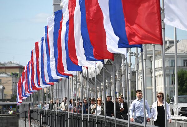 Por toda la capital se organizan desfiles temáticos, conciertos y excursiones. En la foto: banderas en el puente Krimski de Moscú. - Sputnik Mundo