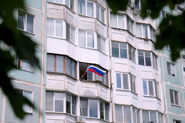 Una bandera rusa en el balcón de un edificio residencial en la capital de la autoproclamada República de Transnistria, Tiráspol, el Día de Rusia. - Sputnik Mundo