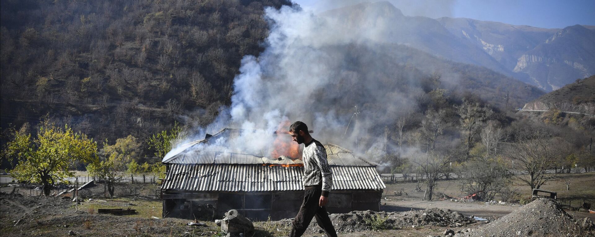 Un hombre observa cómo arde una casa a las afueras de la ciudad de Kalbajar, el 14 de noviembre de 2020, durante el conflicto militar entre Armenia y Azerbaiyán por la región separatista de Nagorno Karabaj.  - Sputnik Mundo, 1920, 15.06.2023