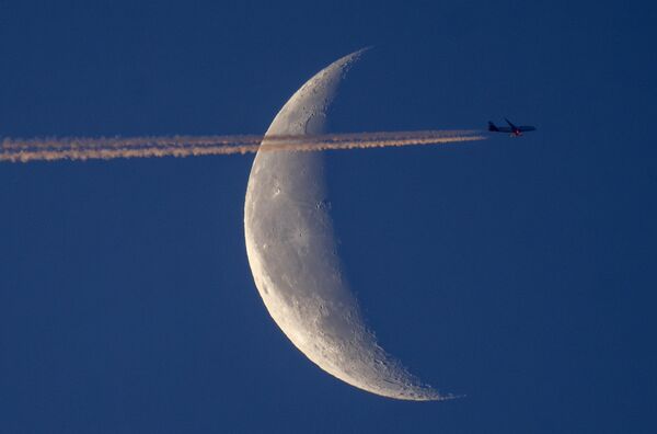 Un avión sobrevuela Fráncfort (Alemania) con la luna creciente de fondo. - Sputnik Mundo