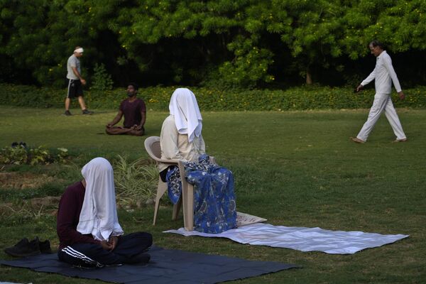 Gente medita a primera hora de la mañana en un parque de Nueva Deli (la India). - Sputnik Mundo
