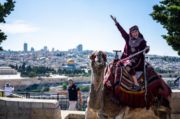 Una turista toma fotos en el monte de los Olivos con la ciudad vieja de Jerusalén de fondo. - Sputnik Mundo