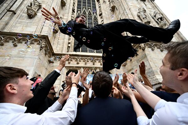 Amigos y familiares felicitan a un sacerdote católico recién ordenado en el exterior de la catedral de Milán (Italia), tras una ceremonia de ordenación. - Sputnik Mundo