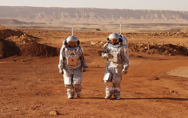 Dos astronautas de un equipo de Europa e Israel caminan con trajes espaciales durante una misión de entrenamiento para el planeta Marte en un lugar que simula una estación cerca del cráter Ramón del consejo local Mitzpé Ramón, en el desierto del Néguev de Israel. - Sputnik Mundo