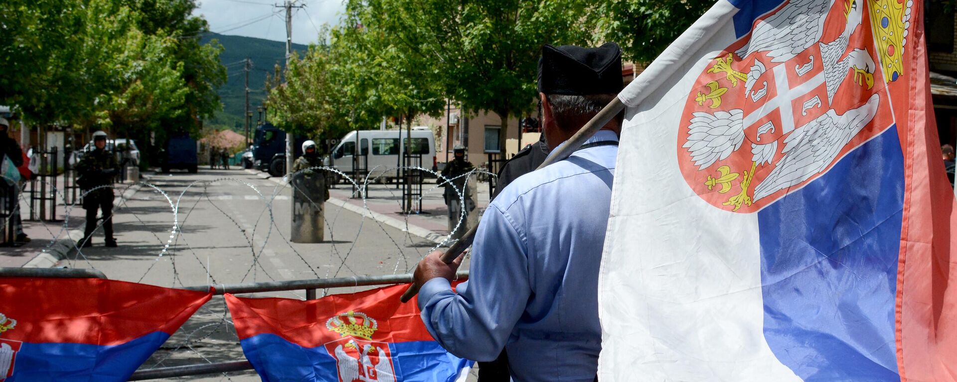 Un hombre con una bandera serbia mira de pie frente a los soldados de la Fuerza Internacional de Seguridad en Kosovo (KFOR), el norte de Kosovo, el 31 de mayo de 2023 - Sputnik Mundo, 1920, 30.06.2023