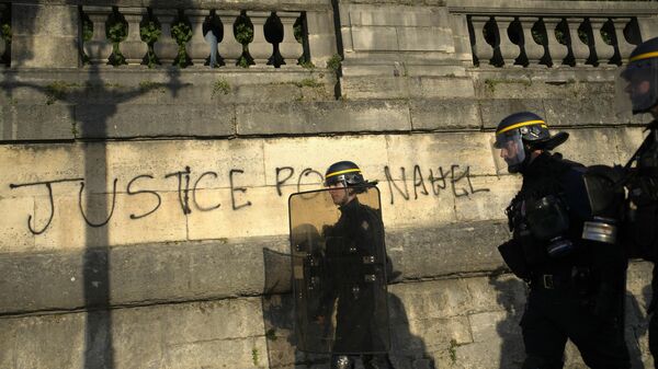  La Policía patrulla junto a una pintada en la que se lee Justicia para Nahel mientras los jóvenes se reúnen en la plaza de la Concordia durante una protesta en París, Francia, el 30 de junio de 2023 - Sputnik Mundo