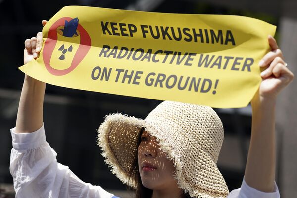 Una manifestante sostiene una pancarta durante una concentración frente a la sede de Tokyo Electric Power Company Holdings (TEPCO) el 16 de mayo de 2023, en Tokio - Sputnik Mundo