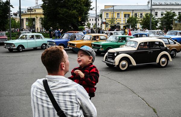 Un hombre con un niño en la exposición de automóviles históricos en el centro de Moscú. - Sputnik Mundo