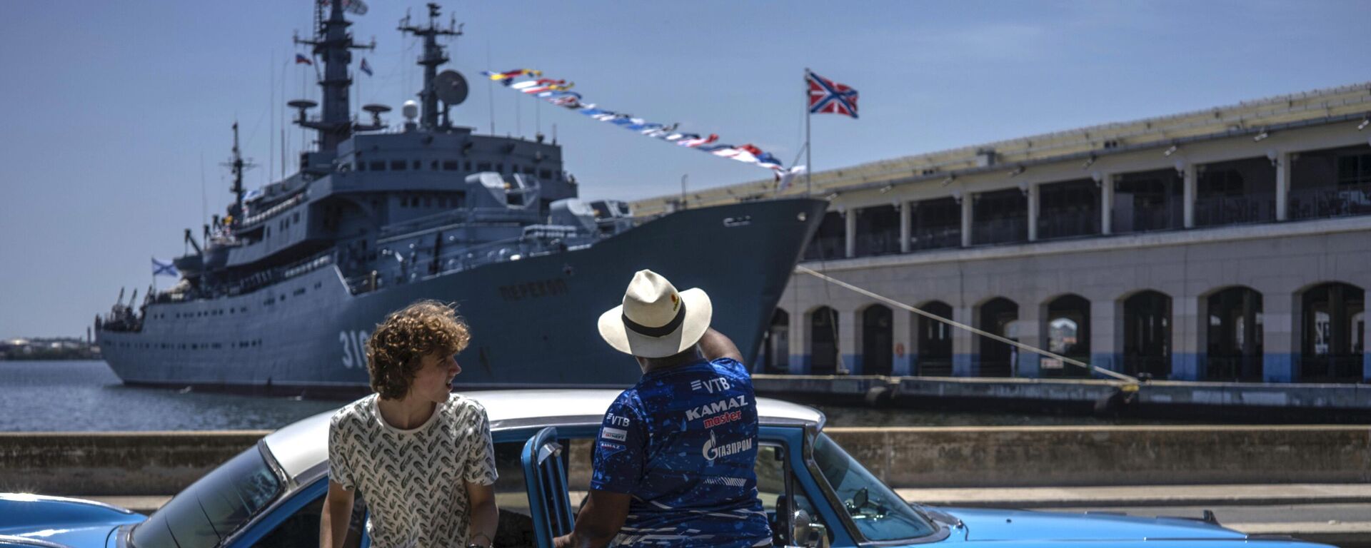 Туристка выходит из классического американского автомобиля перед учебным кораблем ВМФ России Перекоп в Гаванской бухте, Куба - Sputnik Mundo, 1920, 12.07.2023