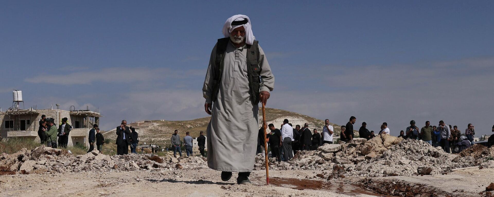 Un anciano palestino se aleja de la multitud mientras excavadoras del Ejército israelí derriban una escuela que, según ellos, fue construida sin permiso en la aldea de Jabbet al-Dhib, al este de Belén, en la Cisjordania ocupada, el 7 de mayo de 2023. - Sputnik Mundo, 1920, 16.07.2023