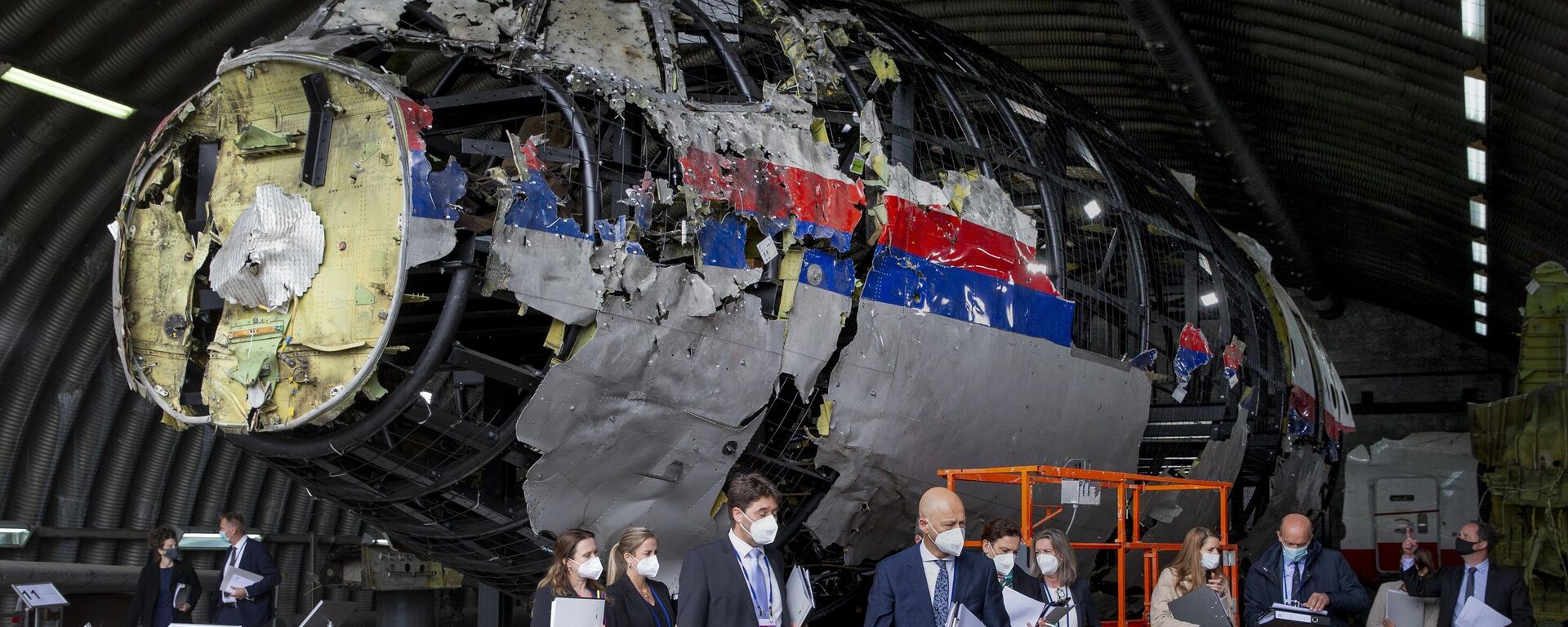 Jueces y abogados observan los restos reconstruidos del vuelo MH17 de Malaysia Airlines, en la base aérea militar de Gilze-Rijen, al sur de los Países Bajos, el 26 de mayo de 2021 - Sputnik Mundo, 1920, 17.07.2023