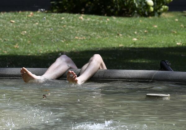 Un hombre evade la ola de calor en una fuente del centro de Zagreb, en Croacia. - Sputnik Mundo