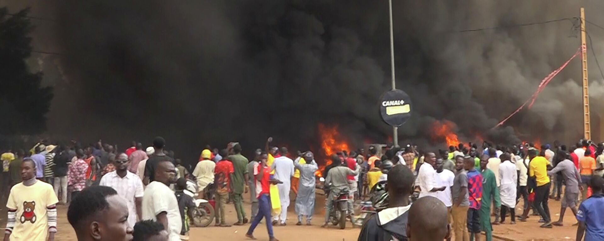 Con la sede del partido gobernante ardiendo por la espalda, partidarios de los soldados amotinados se manifiestan en Niamey, Níger, el jueves 27 de julio de 2023 - Sputnik Mundo, 1920, 31.07.2023