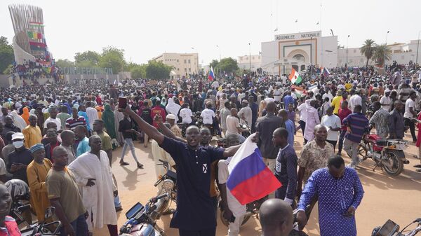 Nigerinos, algunos con banderas rusas, participan en una marcha convocada por los partidarios del golpista general Abdourahmane Tchiani en Niamey, Níger, el 30 de julio de 2023. - Sputnik Mundo