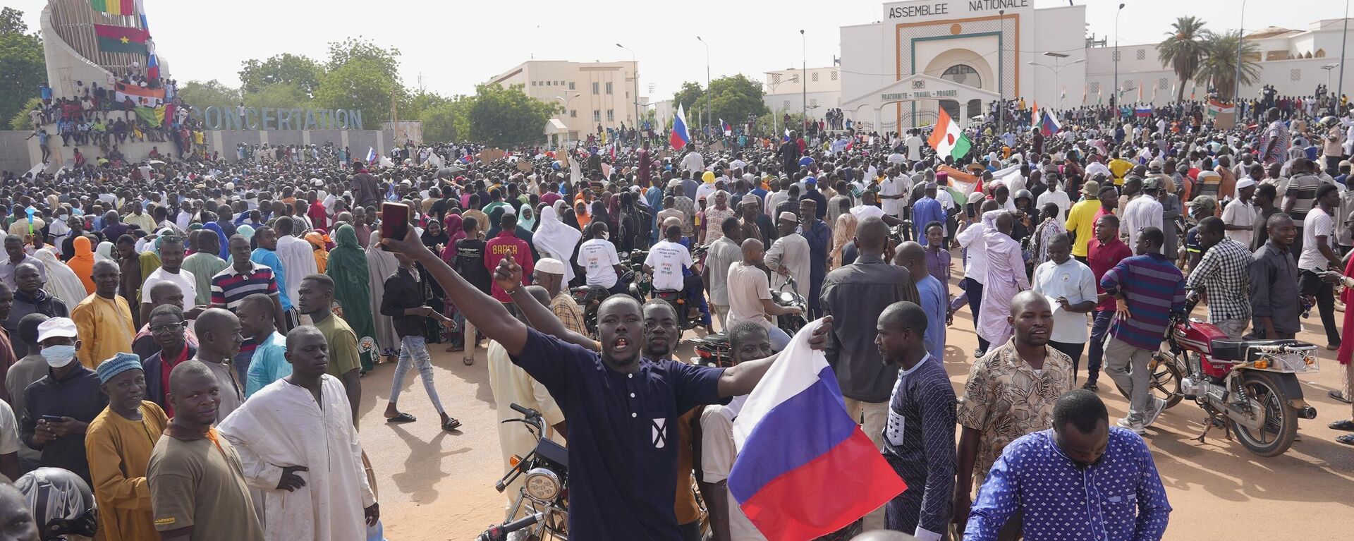Nigerinos, algunos con banderas rusas, participan en una marcha convocada por los partidarios del golpista general Abdourahmane Tchiani en Niamey, Níger, el 30 de julio de 2023.  - Sputnik Mundo, 1920, 30.07.2023