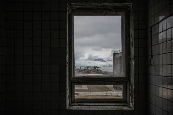 Los turistas son atraídos por la dura naturaleza ártica y la arquitectura soviética local.En la foto: vista desde la ventana del centro cultural abandonado en la localidad de Pyramiden, en la isla de Svalbard. - Sputnik Mundo