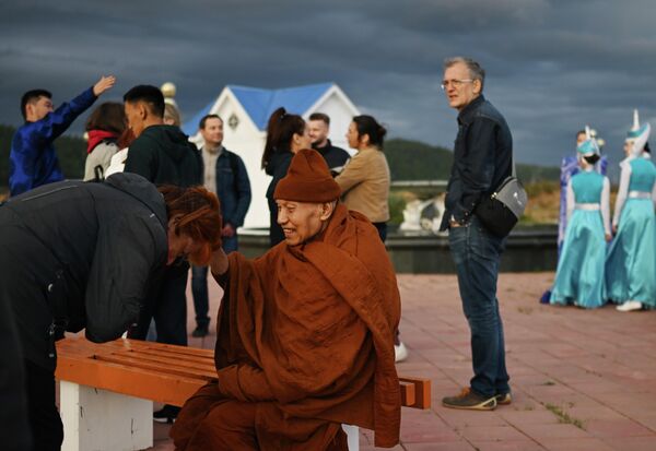 En el Baikal también hay lugares de culto cubiertos de antiguas leyendas.En la foto: turistas y un monje budista en el pueblo de Turka. - Sputnik Mundo