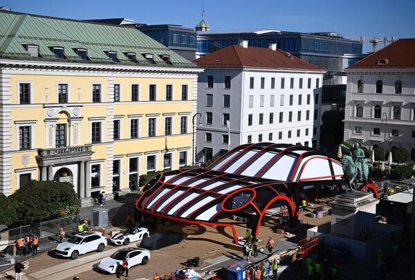 Un stand con la forma de un automóvil Porsche en el Open Space mobility site en Wittelsbacher square, Múnich. - Sputnik Mundo