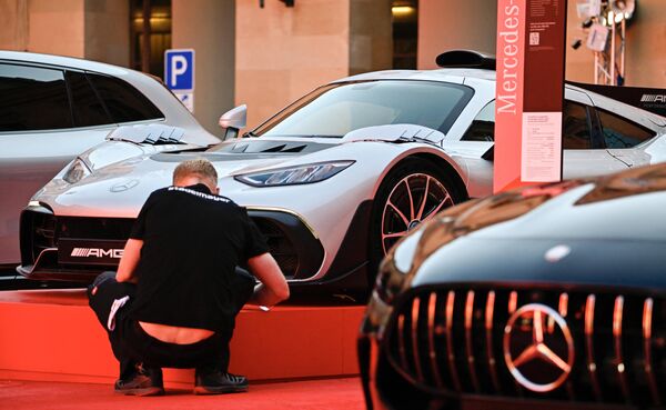Los trabajadores dan los toques finales al stand de Mercedes junto a los modelos Mercedes AMG. - Sputnik Mundo