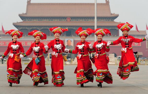 Mujeres representantes de la minoría zhuang de la provincia suroccidental de Guangxi en la Asamblea Popular Nacional de China corren por la plaza de Tiananmén el 8 de marzo de 2008, en Pekín. - Sputnik Mundo