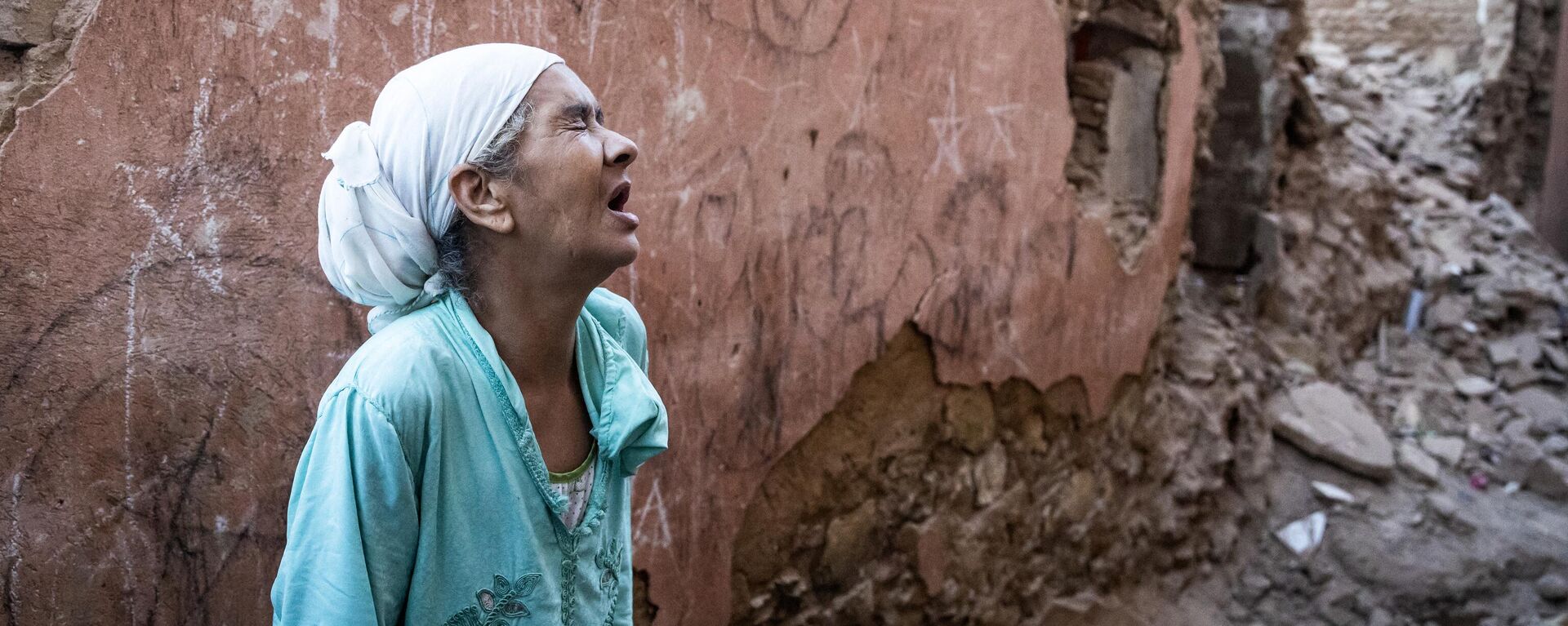 Женщина стоит перед своим поврежденным домом от землетрясения в старом городе Марракеша, Марокко - Sputnik Mundo, 1920, 10.09.2023