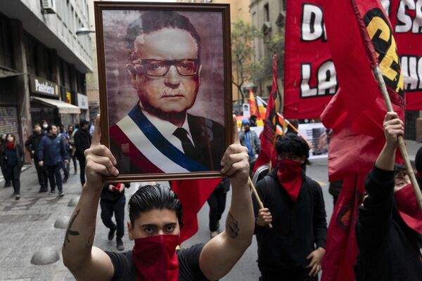 Un hombre con una foto del difunto presidente de Chile Salvador Allende, participa en una manifestación para conmemorar el 50 aniversario del golpe militar encabezado por el general Augusto Pinochet en Santiago de Chile, el 10 de septiembre de 2023. Allende fue asesinado durante el golpe de Estado. - Sputnik Mundo