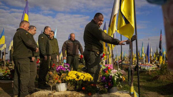 Militares ucranianos depositan flores en la tumba de un soldado en un cementerio de Járkov - Sputnik Mundo
