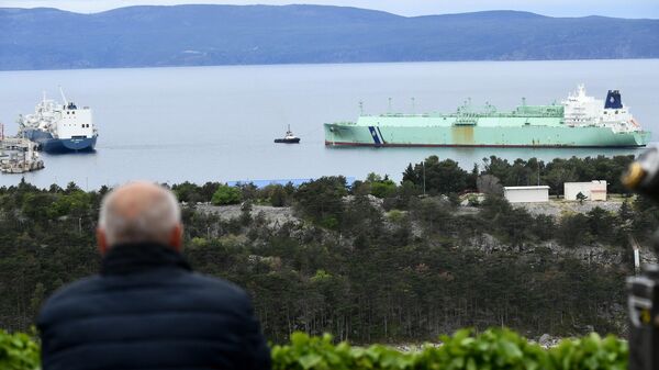 Un hombre observa cómo un barco que transporta gas licuado se acerca a la nueva terminal flotante para gas licuado construida por GNL (gas natural licuado), Croacia  - Sputnik Mundo
