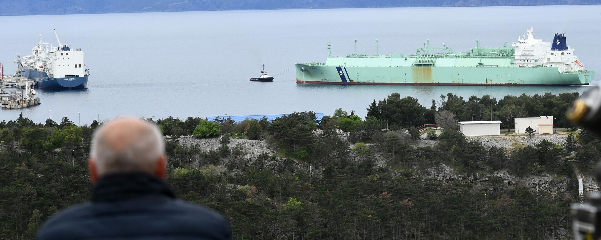 Un hombre observa cómo un barco que transporta gas licuado se acerca a la nueva terminal flotante para gas licuado construida por GNL (gas natural licuado), Croacia  - Sputnik Mundo, 1920, 25.09.2023