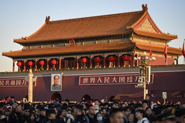 Una de las principales tradiciones de la festividad es el izamiento ceremonial de la bandera en la principal plaza del país, Tiananmén, que debe coincidir con la salida del sol. En la foto: La gente se reúne en la plaza de Tiananmén de Pekín para asistir a la ceremonia de izado de la bandera. - Sputnik Mundo