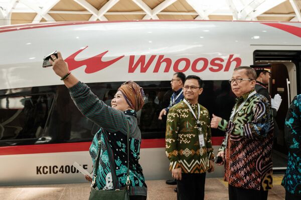 Huéspedes se toman fotos en la estación Halim de Yakarta, cerca del tren de alta velocidad Yakarta-Bandung. - Sputnik Mundo