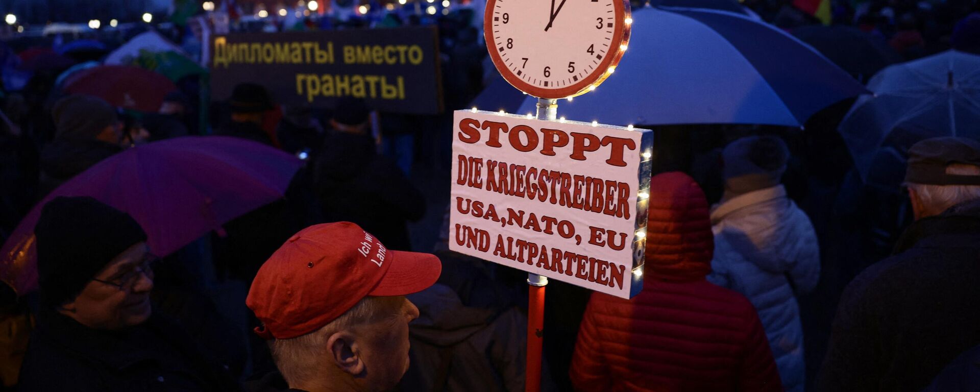 Un hombre sostiene una pancarta con la leyenda Detengan a los belicistas EEUU, la OTAN y la UE durante un mitin de Alternativa para Alemania (AfD), el 24 de febrero de 2023. - Sputnik Mundo, 1920, 03.10.2023