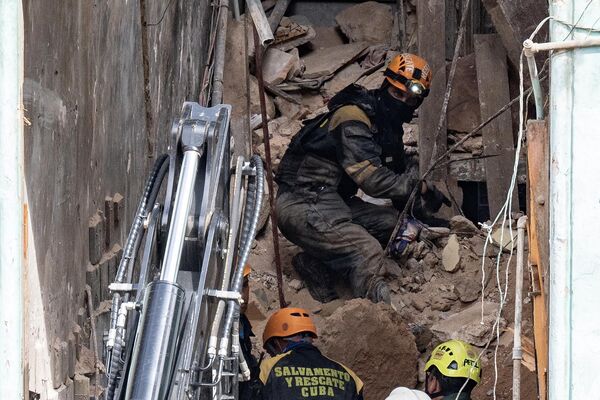 La causa más probable del derrumbe es la antigüedad de la construcción.En la foto: rescatistas trabajando en el bloque de apartamentos tras su derrumbe.  - Sputnik Mundo