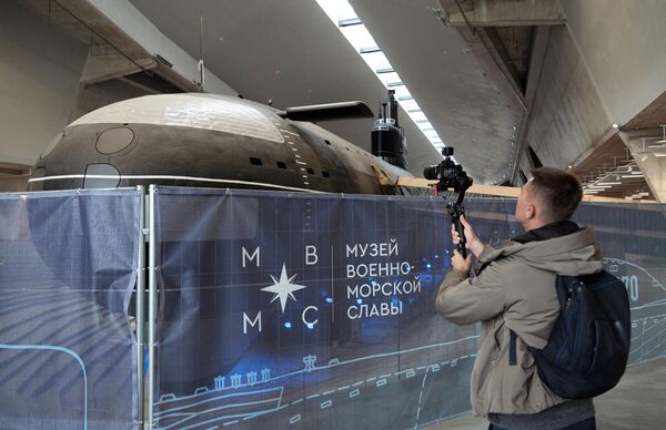 Un hombre filmando el submarino soviético K-3 Leninski Komsomol, que se está restaurando en el Museo de la Gloria Naval en Kronstadt. - Sputnik Mundo