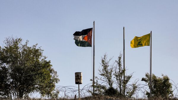 Una bandera palestina y una bandera amarilla del movimiento chií libanés, Hizbulá, en el lado libanés  - Sputnik Mundo