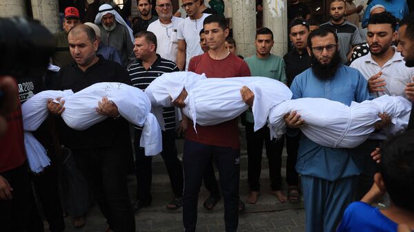 Familiares llevan los cuerpos de los niños de la familia Abu Quta que murieron en los ataques israelíes contra la ciudad palestina de Rafah, en el sur de la Franja de Gaza, durante su funeral el 8 de octubre de 2023. - Sputnik Mundo