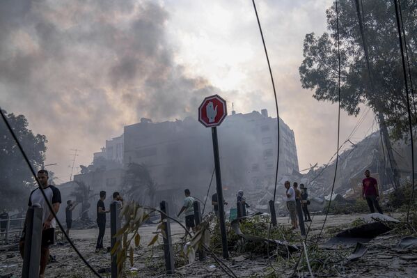 Fuerzas palestinas lanzaron más de 3.000 cohetes contra Israel. Tras los ataques masivos con cohetes, militantes del grupo Hamás se infiltraron en las zonas fronterizas del sur del país, matando y capturando a soldados y civiles israelíes.En la foto: palestinos cerca de un edificio destruido por un ataque israelí en la ciudad de Gaza. - Sputnik Mundo