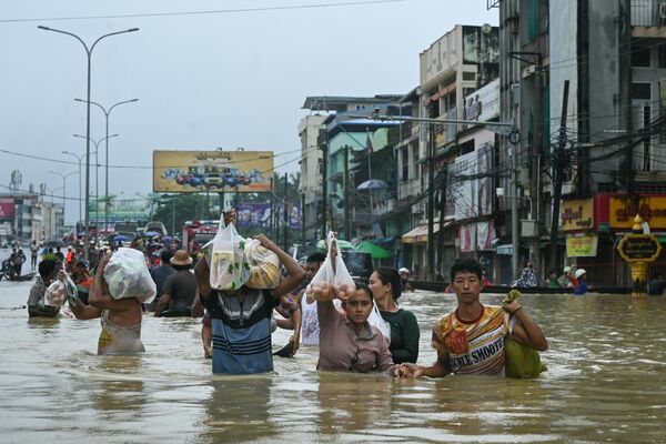 Personas caminando por una calle inundada en la ciudad de Pegu, Birmania. - Sputnik Mundo