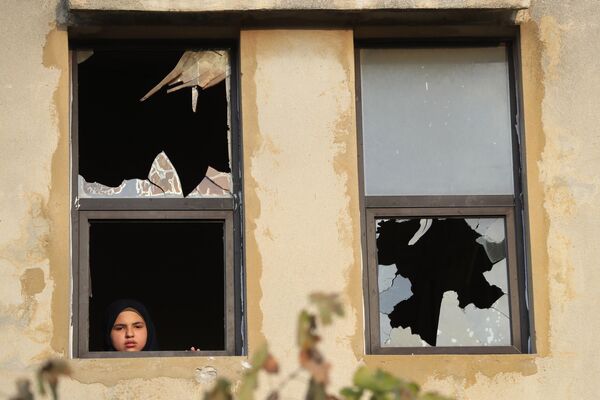 Una niña junto a una ventana destrozada tras la caída de un proyectil israelí cerca de su casa en el pueblo de Dahaira, en el sur del Líbano. - Sputnik Mundo
