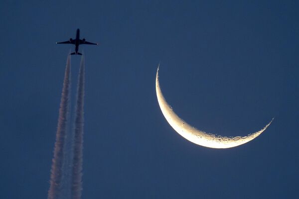 Un avión con la luna de fondo en forma de hoz en el cielo de Fráncfort, Alemania. - Sputnik Mundo